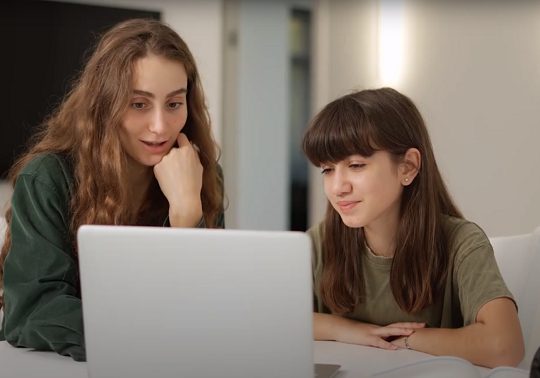 Two young girls using a laptop