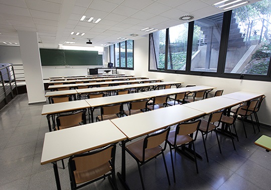 Imatge d'un aula amb taules i cadires
