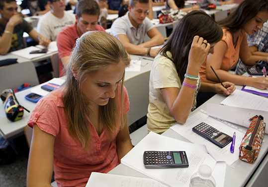 Estudiants i estudiantes de la Universitat en una classe