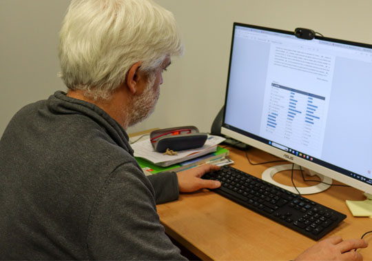 Picture of University staff with a computer.