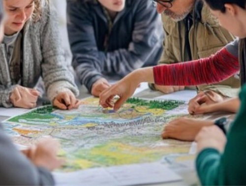 Imatge de persones fent un taller al voltar d'un mapa amb relleu