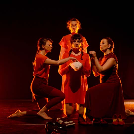 Tres dones i un home en un escenari