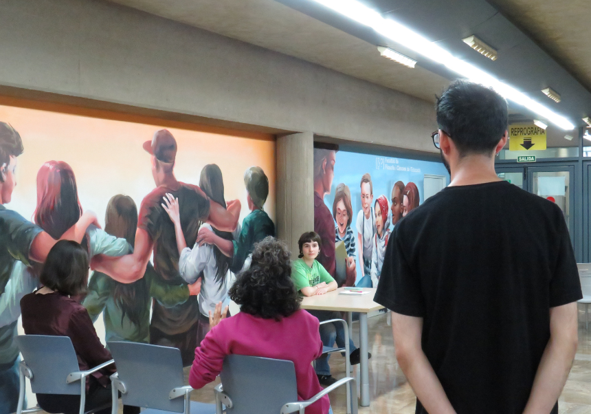 Personas participando en el taller de teatro en la sala de los murales de la Facultat de Filosofia i Ciències de l'Educació
