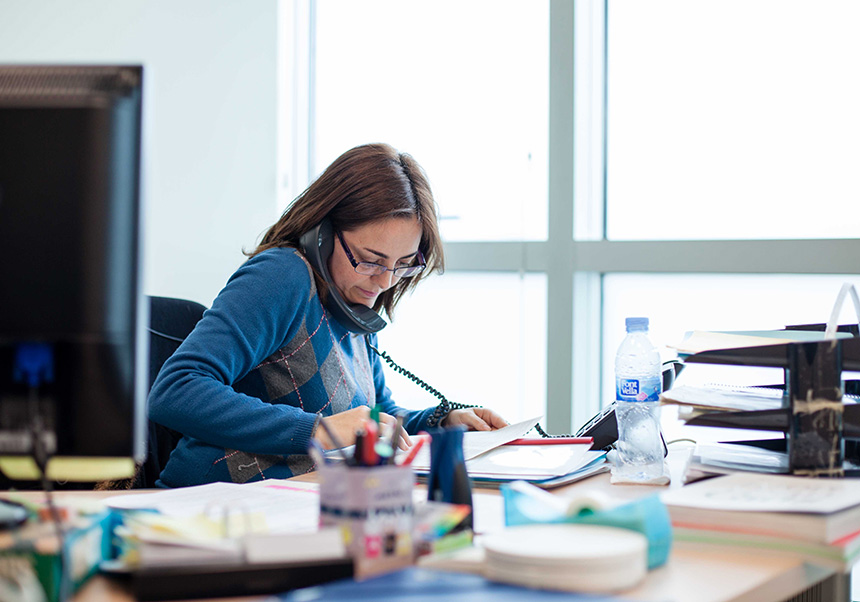 Office worker talking on the telephone and taking notes