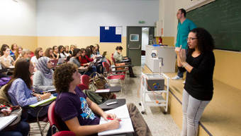An interpreter of Sign Language, in front of a deaf student, in a classroom at the Universitat.