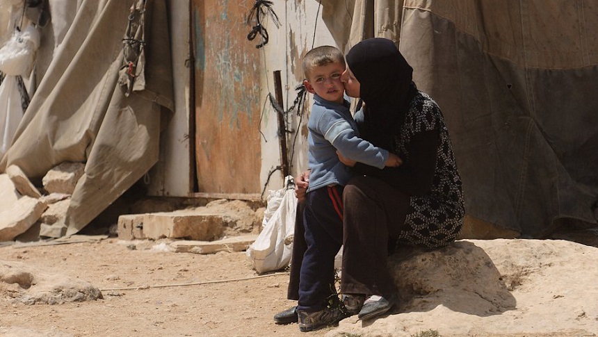 Mujer palestina sentada besando a un niño