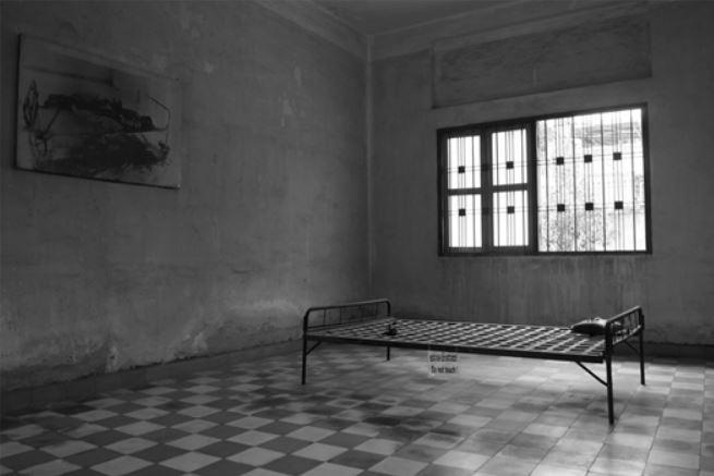 Una cama metálica en una habitación vacía