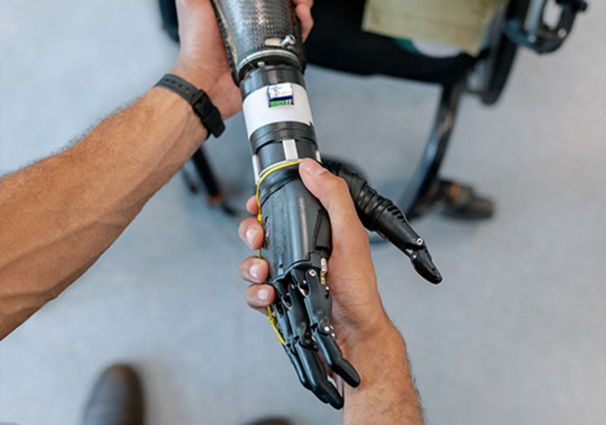 Imagen del evento:Un humano choca la mano a un robot.