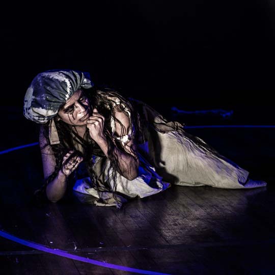 A person crouching on the stage