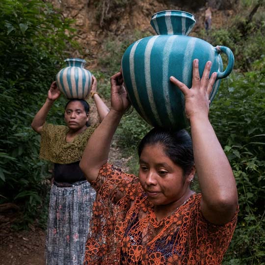 Dos mujeres con un jarrón de agua en la cabeza