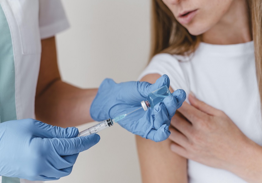 Nurse prepares to vaccinate a girl