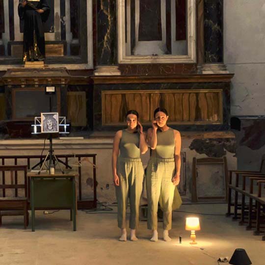 Dos mujeres en un escenario que representa una casa