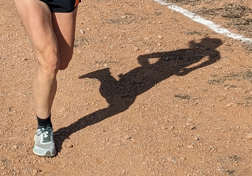 Sombra de una atleta en un momento de la carrera