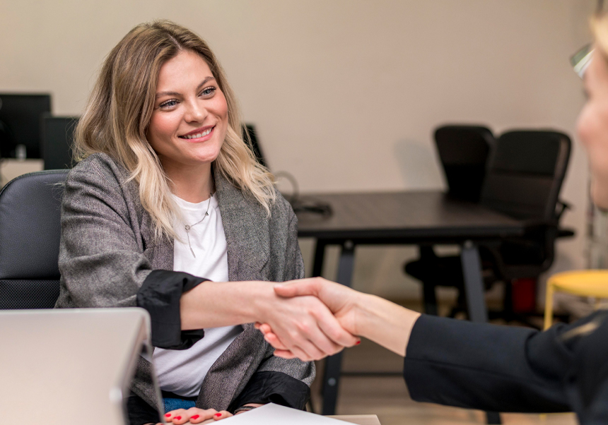Two women shaking hands.