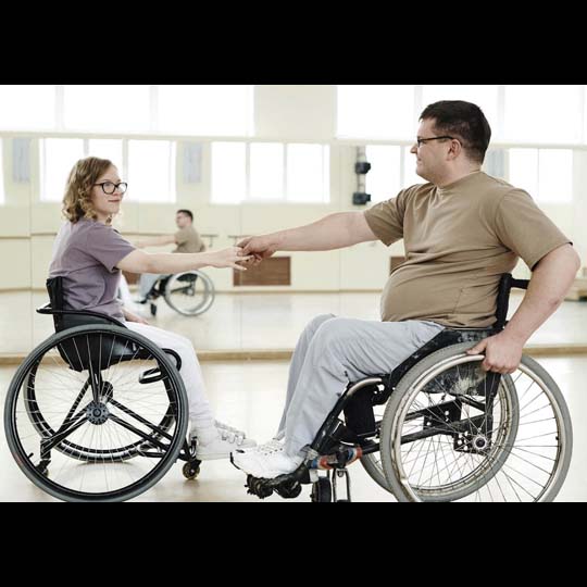 A man and a woman dancing in a wheelchair