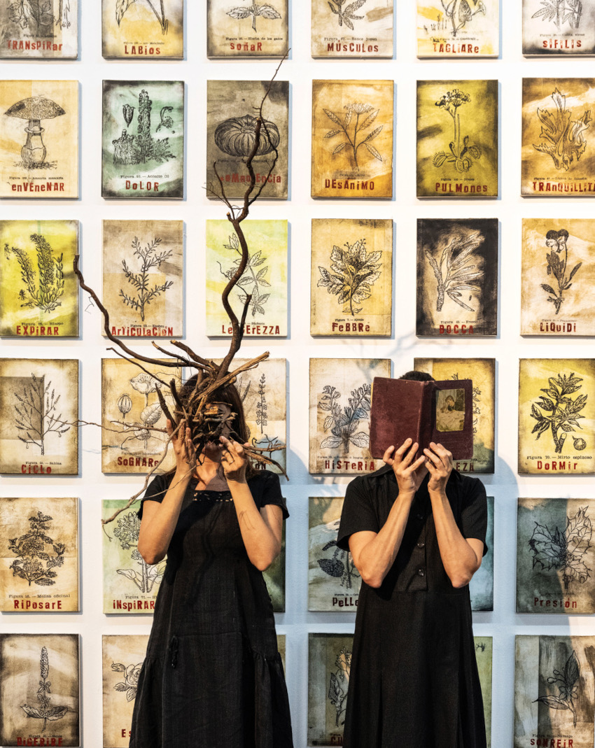 Dues dones amb la cara tapada. Una per branques i l'altra per un llibre