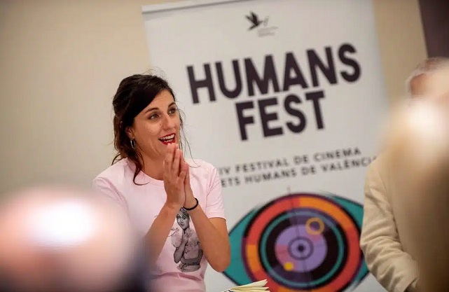 Fotografía d'una dona amb el cartell del festival Humans Fest darrere