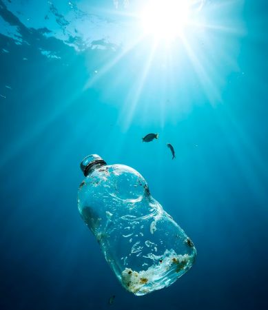Fotografía de botella de plástico contaminando el mar.