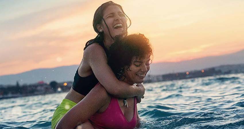 Detalle del cartel. Dos chicas en el mar una encima de la otra