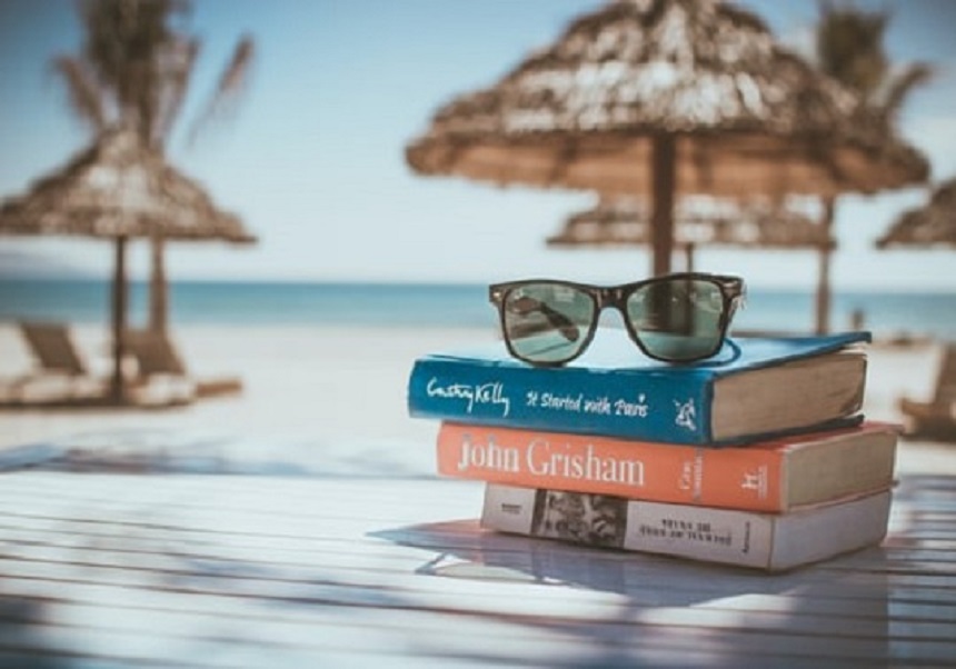 Taula a la platja amb llibres i ulleres de sol