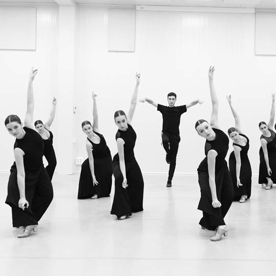 Eight women and one man dancing