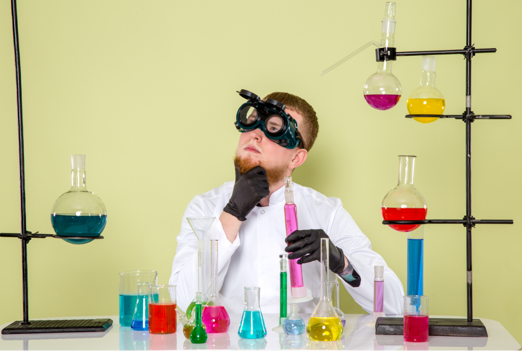 Científic en laboratori envoltat de matrassos, tubs d'assaig i provetes amb líquids de diferents colors
