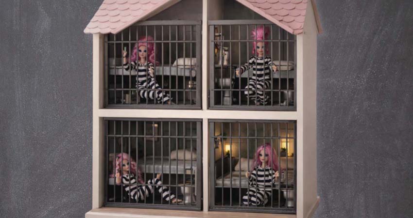 A dollhouse shaped like a prison with four dolls locked inside