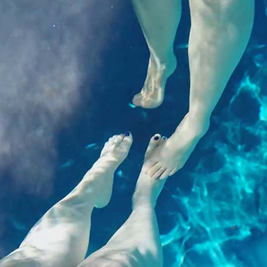 Las piernas de dos personas en una piscina