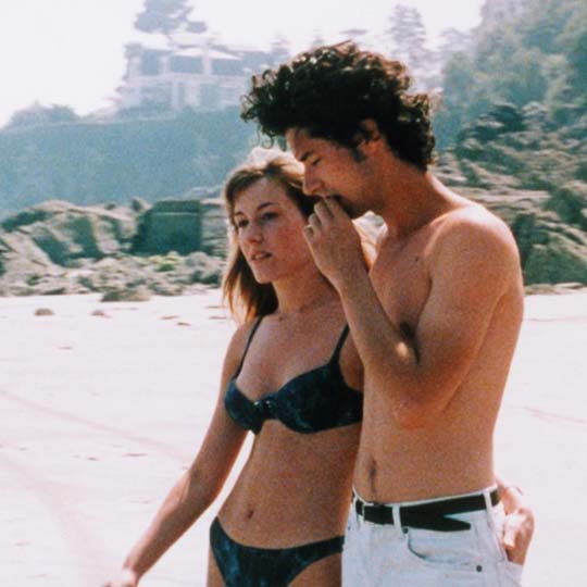 Un chico y una chica paseando por la playa