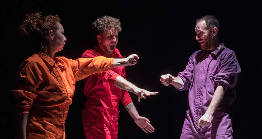 Two man and a woman gesturing on a stage