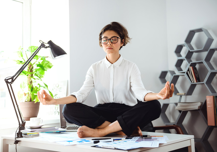 mujer meditando sobre una mesa de despacho