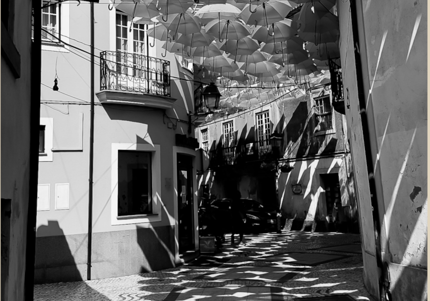 event image:Black and white picture of a cobbled street and a parasol