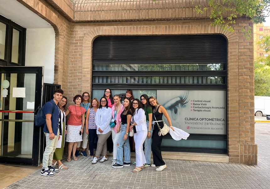 Profesora Valeria Militello con estudiantes en la puerta de la Clínica Optométrica de la Universitat de València