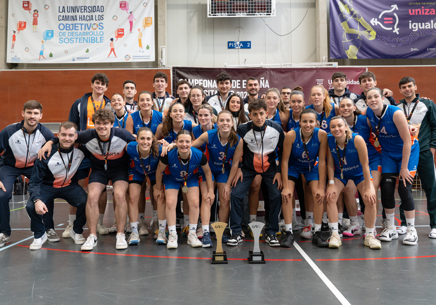 Els equips de bàsquet femení i masculí de la UV posen amb els seus trofeus.