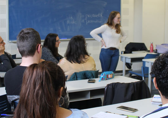 Profesora dando clases en un aula.