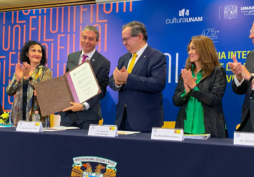 El vicerector Albert Moncusí mostra el reconeixement oficial de la UV com a convidada d'honor de FILUNI 2026 en l'acte inaugural.