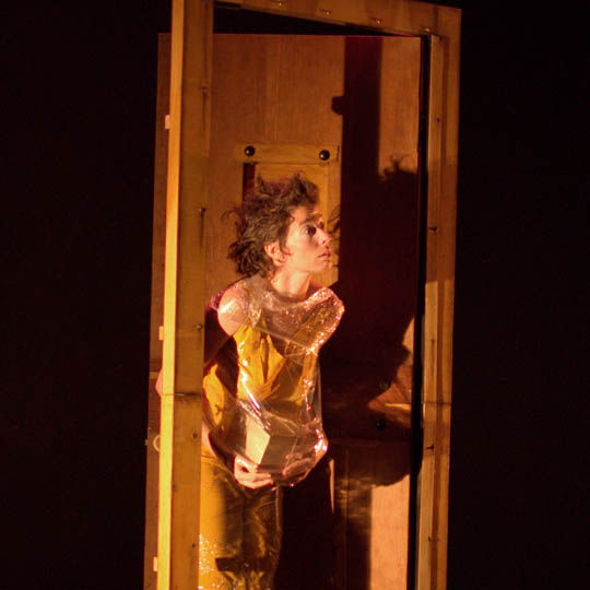 An actor on stage in front of an open door