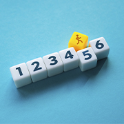 Line of dice from one to five with a yellow die on top of five
