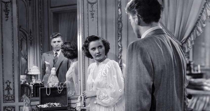 A man and a woman looking at each other and reflecting in a mirror