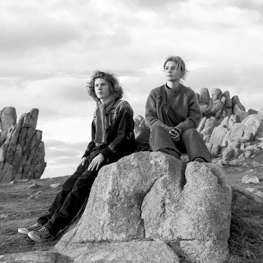 Two women sitting on some stones