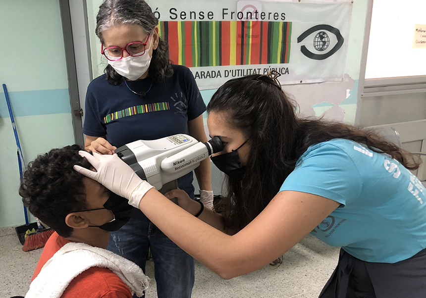 La estudiante Ana Perea valora de forma objetiva la visión de un niño con un autorefractómetro portátil, bajo la supervisión de la profesora Isabel Signes