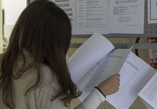 Imatge d'arxiu d'una estudianta consultant llistes.