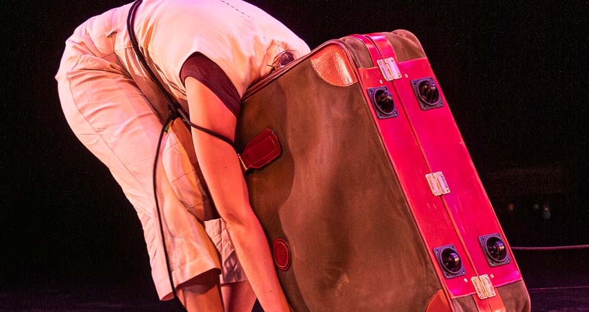 A person with his head inside a suitcase