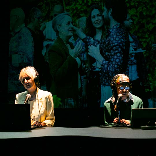 Dos personas en un escenario delante de un ordenador