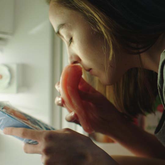 A girl smelling a piece of meat