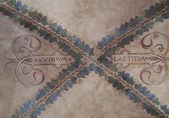 Imagen de un techo policromado con la inscripción 'vinum laetitia'