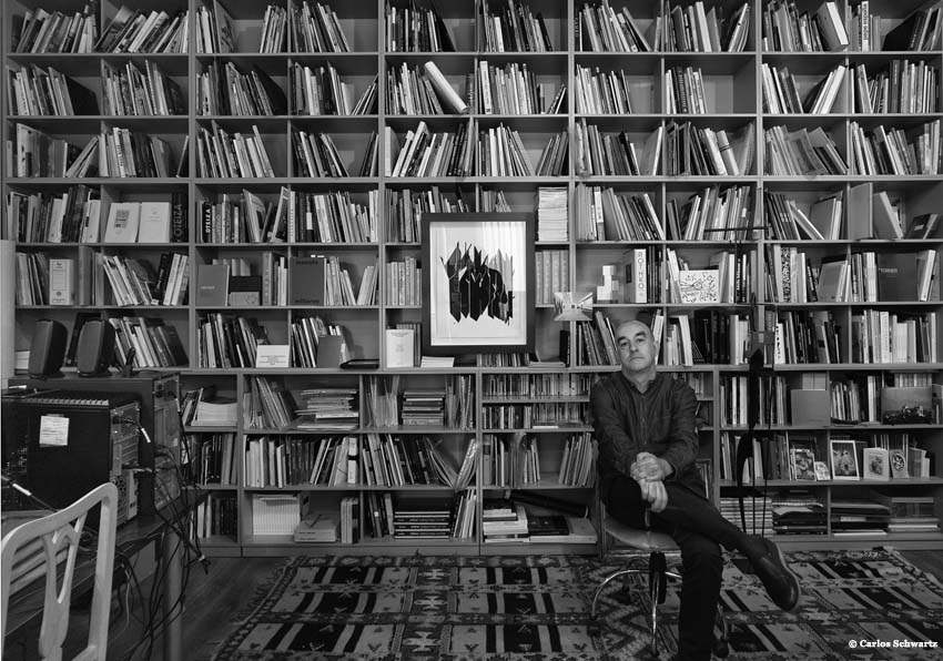 Alfonso de la Torre sitting in front of a bookcase with books