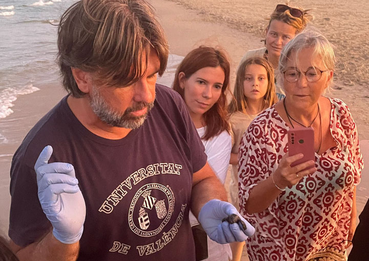 Jesús Tomás, a un nounat en la mà, en una platja.