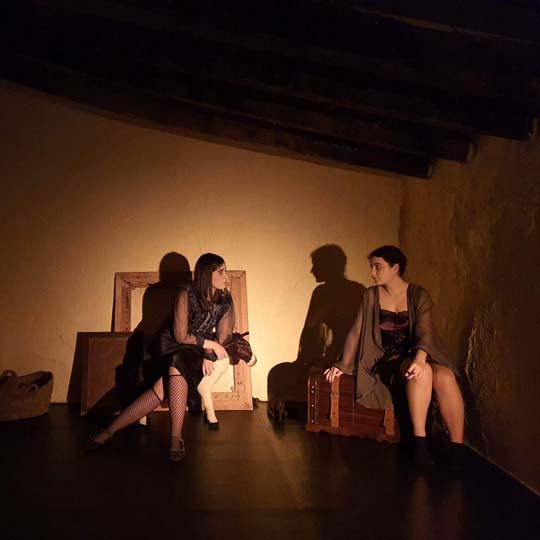 Dos mujeres sentadas hablando en un escenario