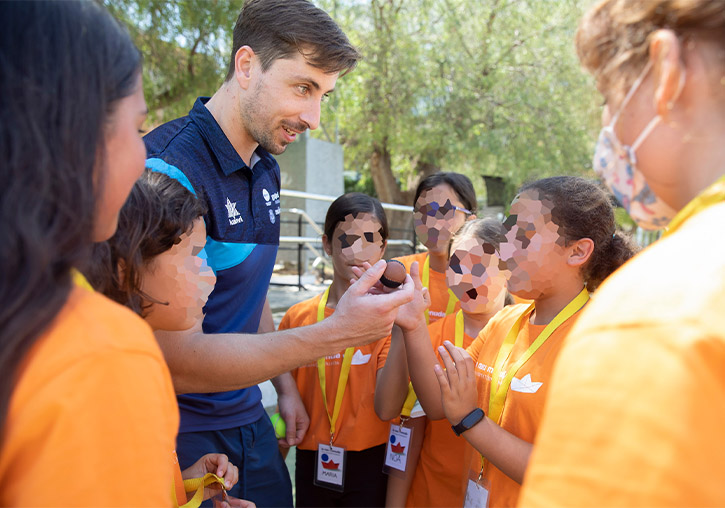 Els campions de pilota transmeten la seua passió als més menuts de l’Escola d’Estiu de la UV